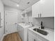 Well-lit laundry room with cabinets, sink, and new washer and dryer at 5433 Chestnut Ridge Rd, Dade City, FL 33523