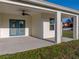 Covered patio area boasts a ceiling fan and entry door, perfect for outdoor entertaining at 5433 Chestnut Ridge Rd, Dade City, FL 33523