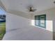 Large covered patio with access to the yard and a ceiling fan at 5433 Chestnut Ridge Rd, Dade City, FL 33523