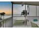 Relaxing screened balcony with ocean view, showing seating and palm trees at 6310 Midnight Pass Rd # 204N, Sarasota, FL 34242