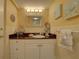 Charming bathroom with a decorative vanity, art and nautical decor, with white cabinets and a decorative mirror at 6310 Midnight Pass Rd # 204N, Sarasota, FL 34242