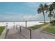 Beautifully landscaped walkway to white sandy beach with palm trees under a sunny sky at 6310 Midnight Pass Rd # 204N, Sarasota, FL 34242