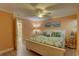Bright bedroom with a tropical aesthetic with a ceiling fan, white furniture, and decor with beach and boat themes at 6310 Midnight Pass Rd # 204N, Sarasota, FL 34242
