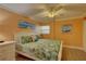 Bright bedroom with a tropical aesthetic with a ceiling fan, white furniture, and decor with beach and boat themes at 6310 Midnight Pass Rd # 204N, Sarasota, FL 34242