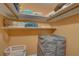 Storage closet with white shelving, packed with folded linens, storage bags, and a laundry basket on the floor at 6310 Midnight Pass Rd # 204N, Sarasota, FL 34242