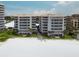 Exterior view of beachside condo buildings with direct beach access and manicured lawn at 6310 Midnight Pass Rd # 204N, Sarasota, FL 34242