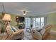 Bright living room with comfortable seating, stylish decor, and sliding doors to the balcony with ocean view at 6310 Midnight Pass Rd # 204N, Sarasota, FL 34242