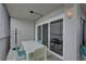 Outdoor patio offers seating with a table and chairs, and a sliding glass door to an indoor seating area at 6310 Midnight Pass Rd # 204N, Sarasota, FL 34242