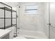 Bright, renovated bathroom featuring sleek white tiles, a shower-tub combo, and modern chrome fixtures at 673 Folsom S St, St Petersburg, FL 33707