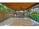 This outdoor kitchen features granite counters, a grill, a bench, a ceiling fan, recessed lighting and a wooden cover at 6791 17Th N St, St Petersburg, FL 33702