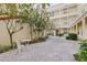 View of a serene courtyard with seating and mature trees at 701 Mirror Lake N Dr # 216, St Petersburg, FL 33701