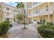 The courtyard features manicured shrubs, pavers, and wrought iron furniture at 701 Mirror Lake N Dr # 216, St Petersburg, FL 33701