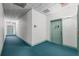 Hallway featuring carpeted floors and aqua colored doors at 701 Mirror Lake N Dr # 216, St Petersburg, FL 33701