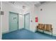 Hallway featuring carpeted floors, two chairs, and aqua colored doors at 701 Mirror Lake N Dr # 216, St Petersburg, FL 33701