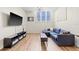 Bright living room features a comfortable blue sectional sofa, wood floors, and a large window for natural light at 701 Mirror Lake N Dr # 216, St Petersburg, FL 33701