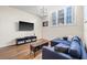 Stylish living area with a modern chandelier, large windows, and a comfortable blue sectional sofa at 701 Mirror Lake N Dr # 216, St Petersburg, FL 33701
