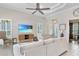 Comfortable living room features a ceiling fan, plantation shutters and entertainment center at 7233 Whittlebury Trl, Bradenton, FL 34202