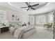 Bright main bedroom with neutral color palette, tray ceiling, large windows and plantation shutters at 7233 Whittlebury Trl, Bradenton, FL 34202