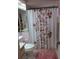 Bathroom featuring floral shower curtain, pink rug, vanity and mirror at 8055 Picketts Ct # 1, Weeki Wachee, FL 34613