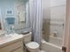 Bathroom features a shower/tub combo with a blue and white striped curtain, toilet, and vanity at 8055 Picketts Ct # 1, Weeki Wachee, FL 34613