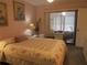 Bedroom featuring pink walls, floral bedding, a desk area, and a view of the patio at 8055 Picketts Ct # 1, Weeki Wachee, FL 34613