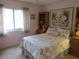 Bedroom with beach themed decor, featuring bed, dresser, nightstand and ceiling fan at 8055 Picketts Ct # 1, Weeki Wachee, FL 34613