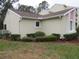 A view of the exterior featuring beige stucco and a neatly landscaped yard with well-maintained shrubs and mulch at 8055 Picketts Ct # 1, Weeki Wachee, FL 34613