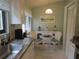 Bright breakfast nook features a white wicker dining set, a white sideboard, and kitchen cabinets at 8055 Picketts Ct # 1, Weeki Wachee, FL 34613