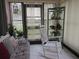 Bright sun room with tile flooring, rocking chair, lots of natural light from the large sliding doors and multiple plants at 8055 Picketts Ct # 1, Weeki Wachee, FL 34613