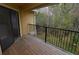 This balcony features a wooden floor, black metal railing, and nature views at 8659 Fancy Finch Dr # 202, Tampa, FL 33614