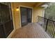 This balcony features a wooden floor, black metal railing, and an open patio door at 8659 Fancy Finch Dr # 202, Tampa, FL 33614