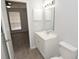Well-lit bathroom with white vanity, mirror, and toilet, featuring modern fixtures and gray wood-look flooring at 8659 Fancy Finch Dr # 202, Tampa, FL 33614