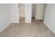 Bedroom showcasing wood-look flooring with an adjoining bathroom, and a doorway to a walk-in closet at 8659 Fancy Finch Dr # 202, Tampa, FL 33614