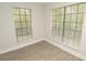 Bedroom featuring two large windows with blinds and clean, modern flooring for a minimalist aesthetic at 8659 Fancy Finch Dr # 202, Tampa, FL 33614