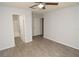 Bedroom with wood-look flooring, ceiling fan, and connections to the bathroom and walk-in closet at 8659 Fancy Finch Dr # 202, Tampa, FL 33614
