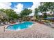Community swimming pool with brick-paved deck, lounge chairs, and lush landscaping at 8659 Fancy Finch Dr # 202, Tampa, FL 33614