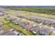 An aerial view of a neighborhood showcasing a house with a manicured lawn, adjacent to a scenic pond and green space at 9313 Channing Hill Dr, Ruskin, FL 33573