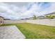 Expansive backyard featuring green grass, a paved patio, and a white vinyl fence for privacy at 9313 Channing Hill Dr, Ruskin, FL 33573