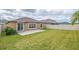 The home's backyard features green grass, a stone patio, and a white fence at 9313 Channing Hill Dr, Ruskin, FL 33573