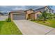 Charming home with a two-car garage, well-manicured lawn, and freshly mulched landscaping along the front at 9313 Channing Hill Dr, Ruskin, FL 33573