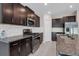 Modern kitchen boasts stainless steel appliances, granite countertops, tile backsplash and ample dark wood cabinetry at 9313 Channing Hill Dr, Ruskin, FL 33573