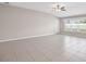 Spacious living room with light tile flooring, a large window, and a ceiling fan at 9313 Channing Hill Dr, Ruskin, FL 33573