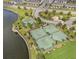Aerial view of community tennis and basketball courts next to a scenic pond and lush landscaping at 9313 Channing Hill Dr, Ruskin, FL 33573