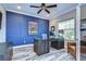 Stylish home office with a dark blue accent wall, modern desk, and wood-look tile flooring at 11882 Frost Aster Dr, Riverview, FL 33579