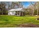 Charming cottage-style home with metal roof, screened porch, and mature trees on a spacious lot at 13381 Glory Ln, Brooksville, FL 34614