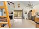 Open concept living room with a fireplace, dining area, chandelier, and ladder at 13381 Glory Ln, Brooksville, FL 34614