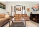 Cozy living room featuring a brown sofa, fireplace, and natural light at 13381 Glory Ln, Brooksville, FL 34614