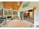 Large screened porch with wood ceiling, grill, and dining area, transitioning to a modern kitchen at 13381 Glory Ln, Brooksville, FL 34614