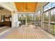 Expansive screened porch with outdoor seating, ceiling fan, and views of the wooded surroundings at 13381 Glory Ln, Brooksville, FL 34614