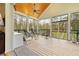 Screened porch offering an outdoor sitting area with wood floors and views of the surrounding greenery at 13381 Glory Ln, Brooksville, FL 34614